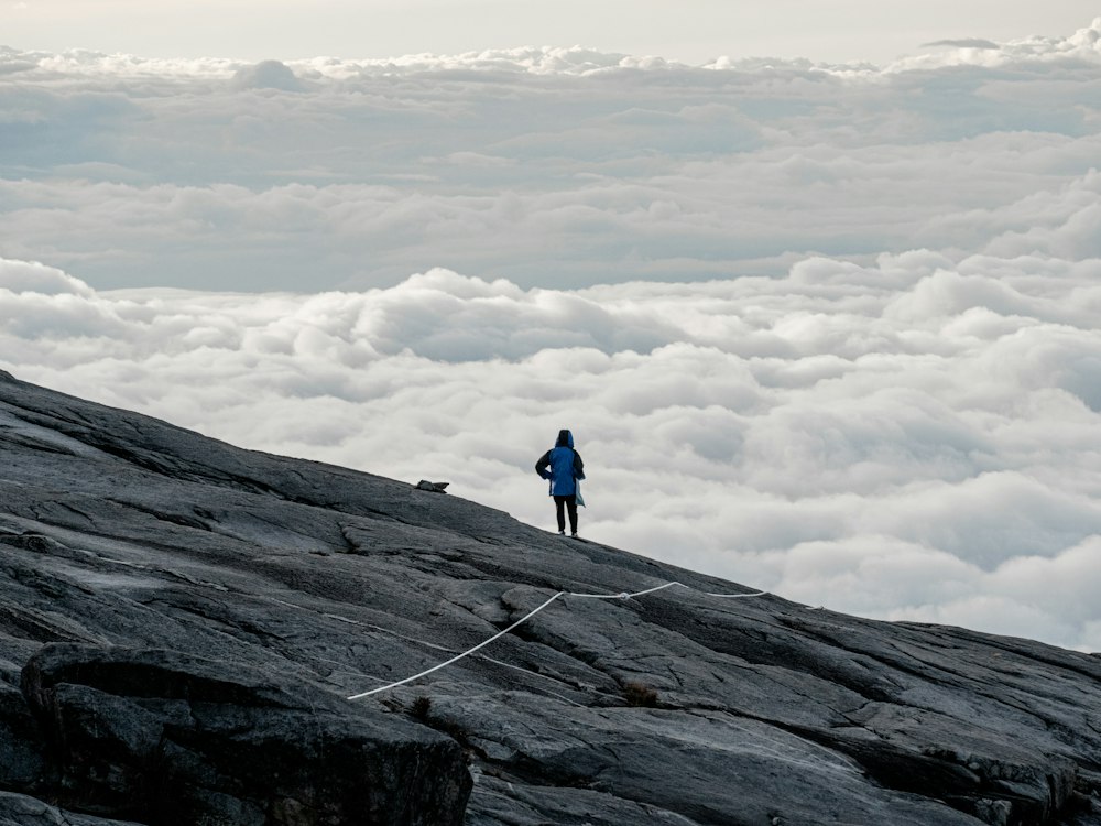 Hiker standing on a mountain above the clouds in Malaysia
