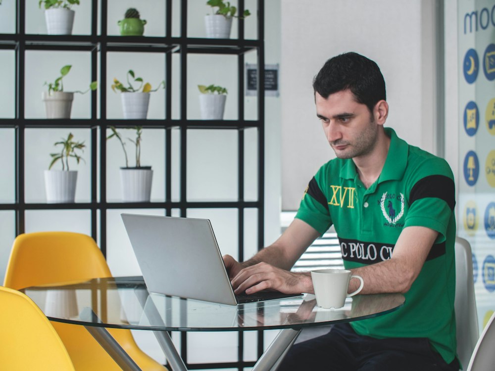 Man working on a laptop in a bright cafe